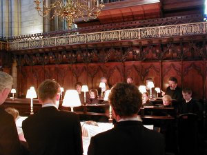 The choir rehearse in the choir stalls at Chichester Cathedral